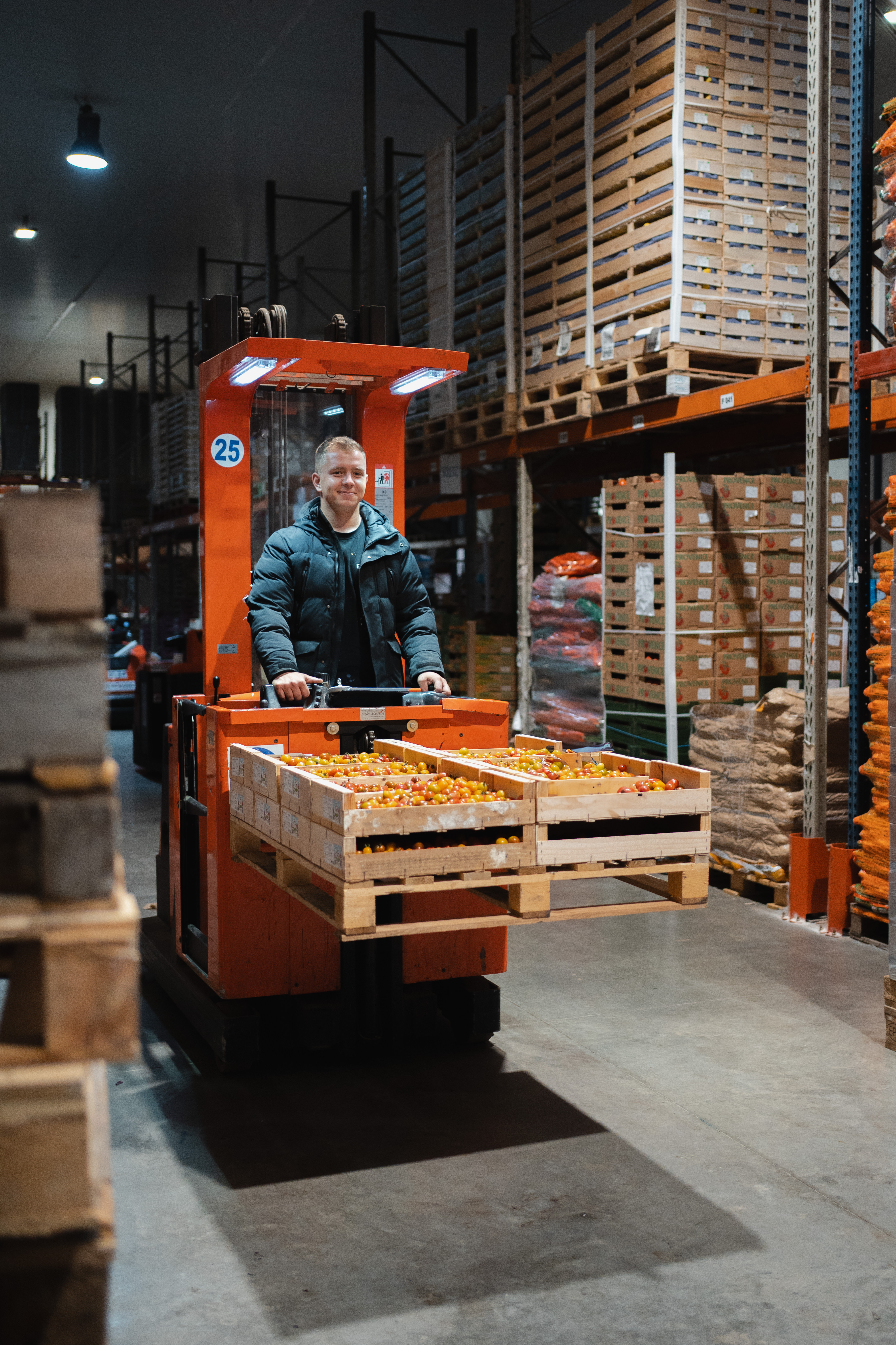 Un apprenti apprends sur un chariot élévateur et transporte des aliments.