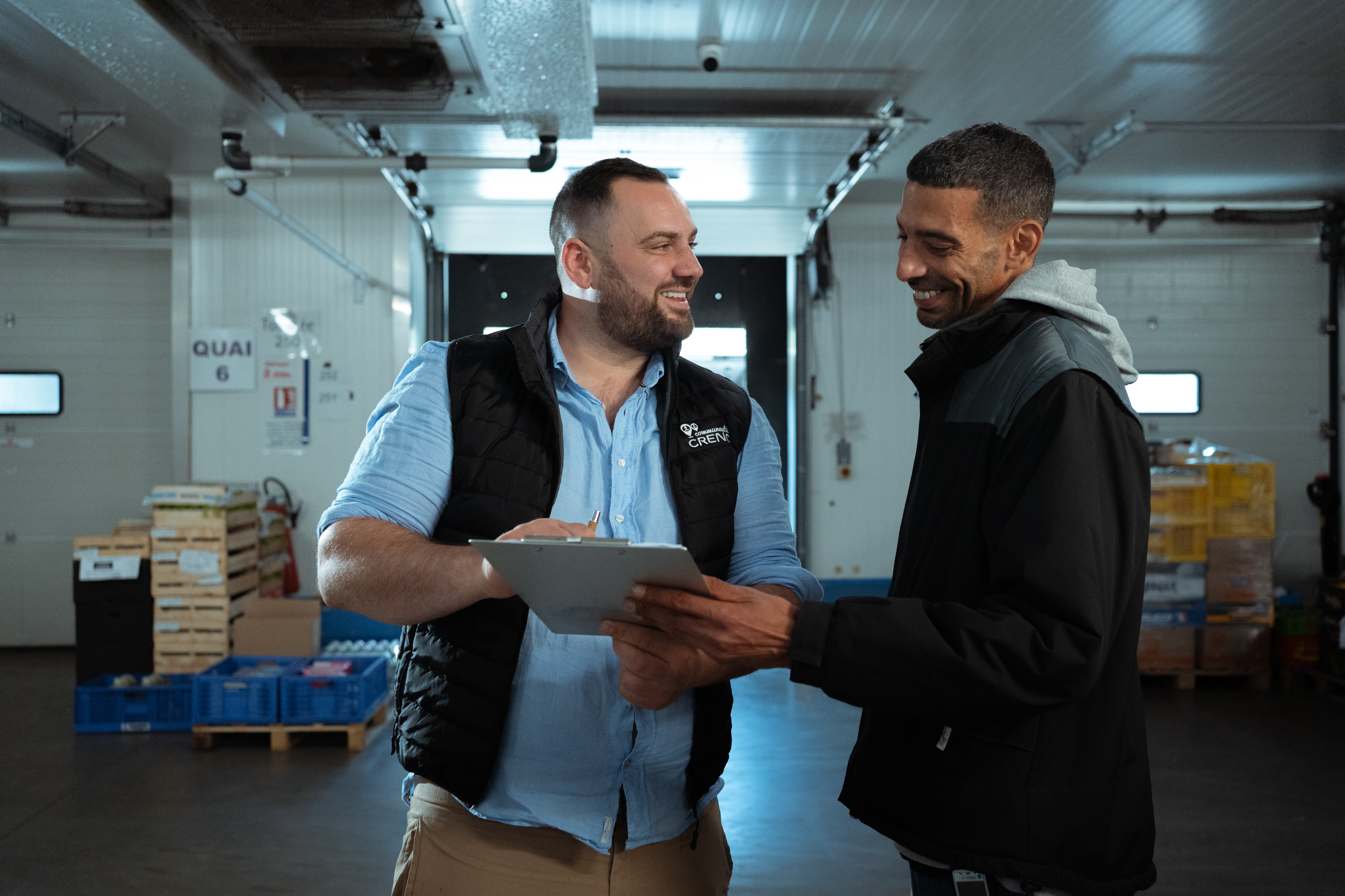 Une collaborateur du réseau Creno signe un contrat avec une autre dans un entrepôt